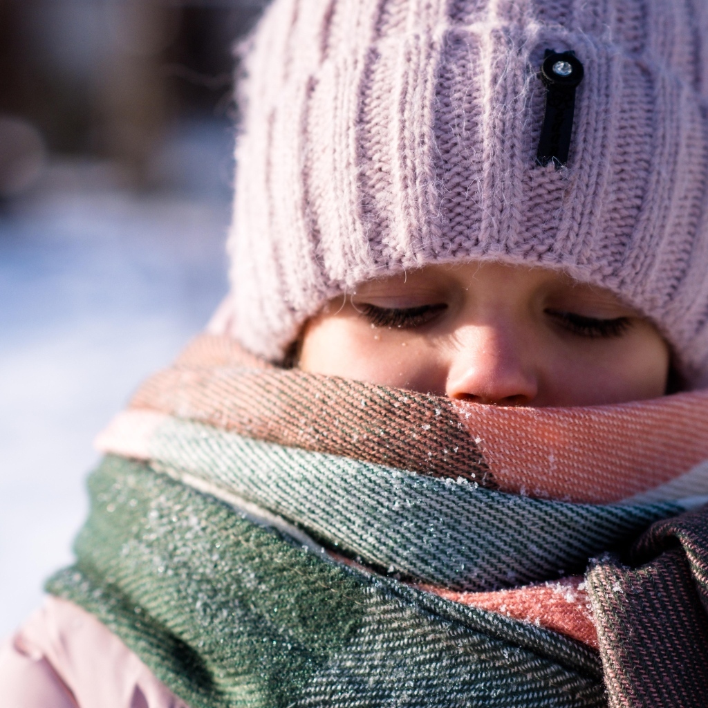 Девочка в теплой вязаной шапке зимой