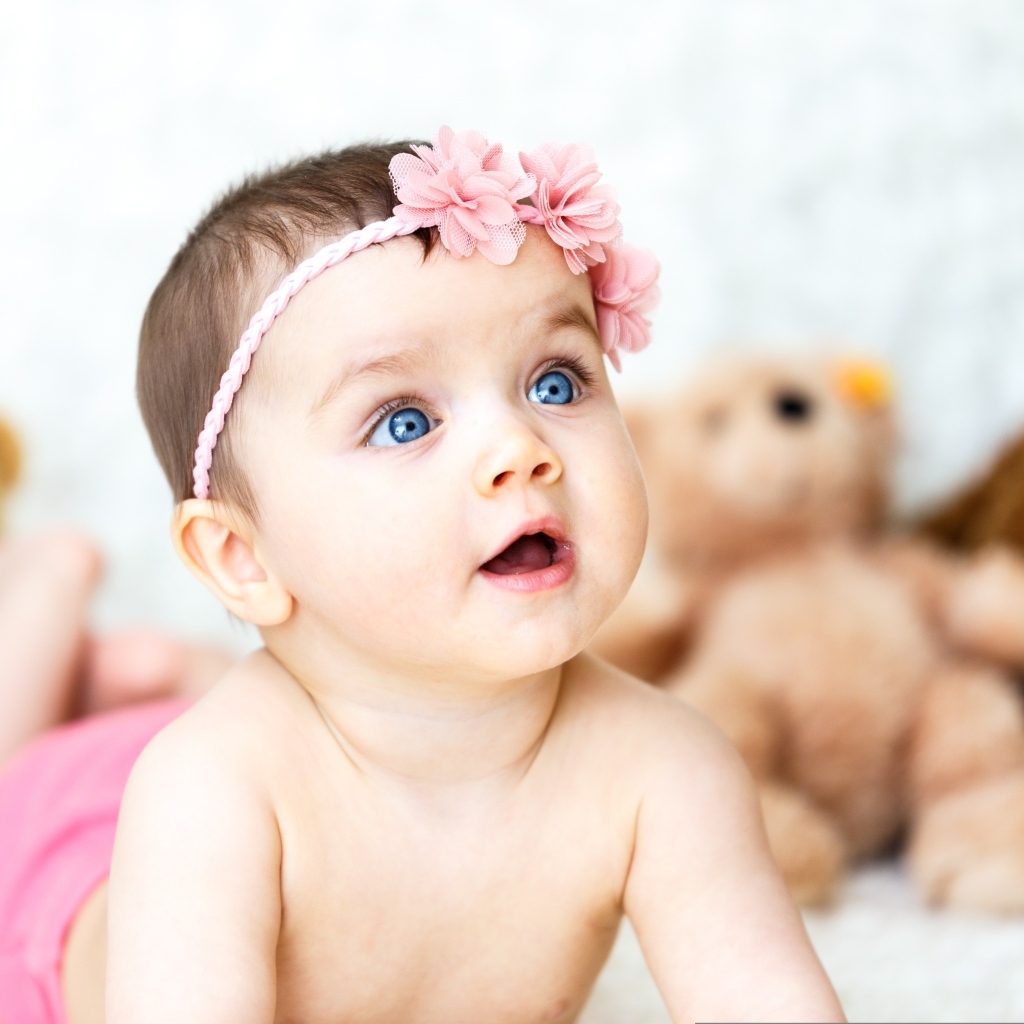 Девочка с голубыми глазами на фоне игрушек