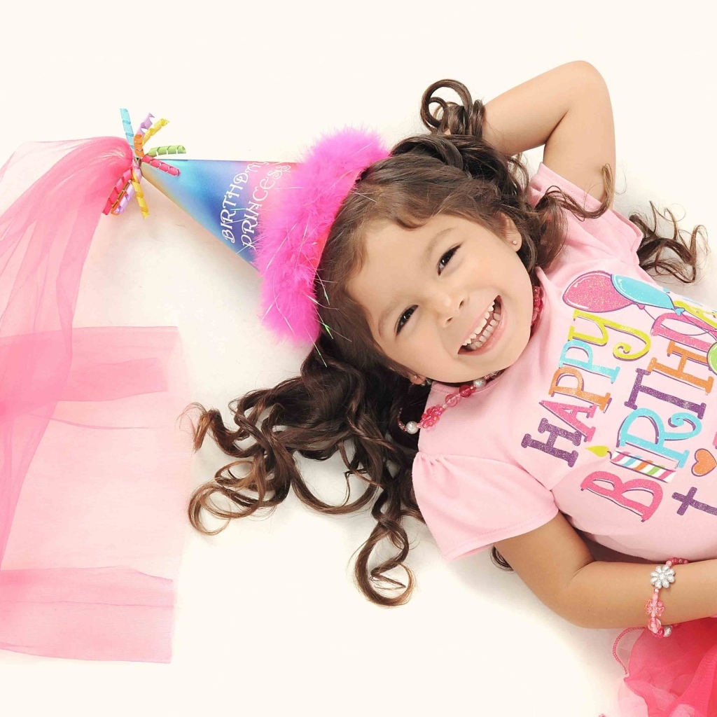 Счастливая маленькая девочка в костюме на день рождения