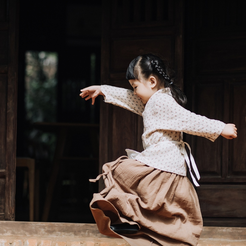 Маленькая девочка азиатка танцует