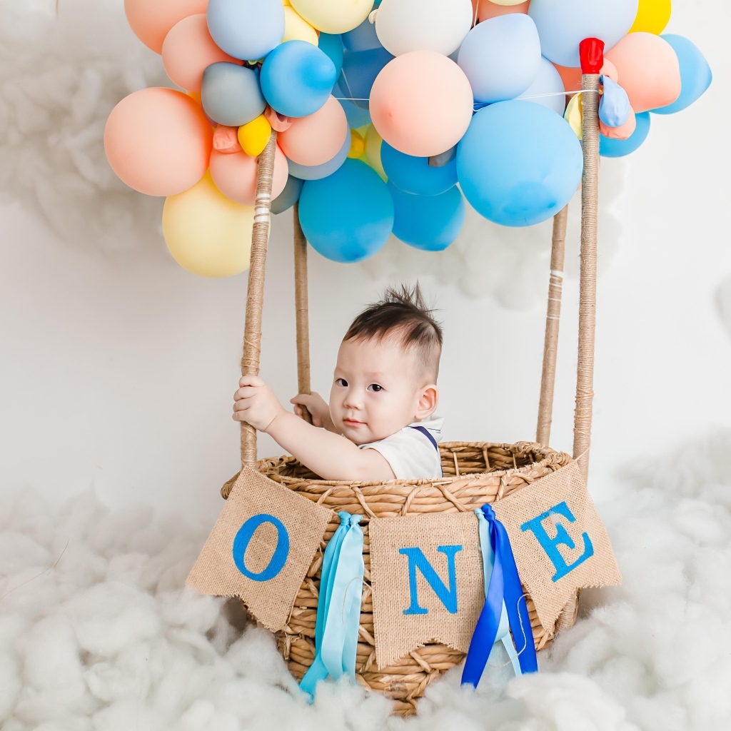 Маленький мальчик в корзине с воздушными шарами