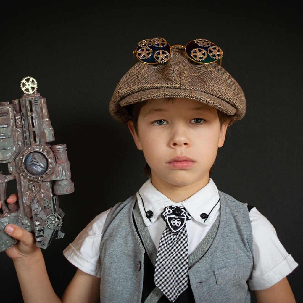 Маленький мальчик с игрушечным пистолетом на черном фоне