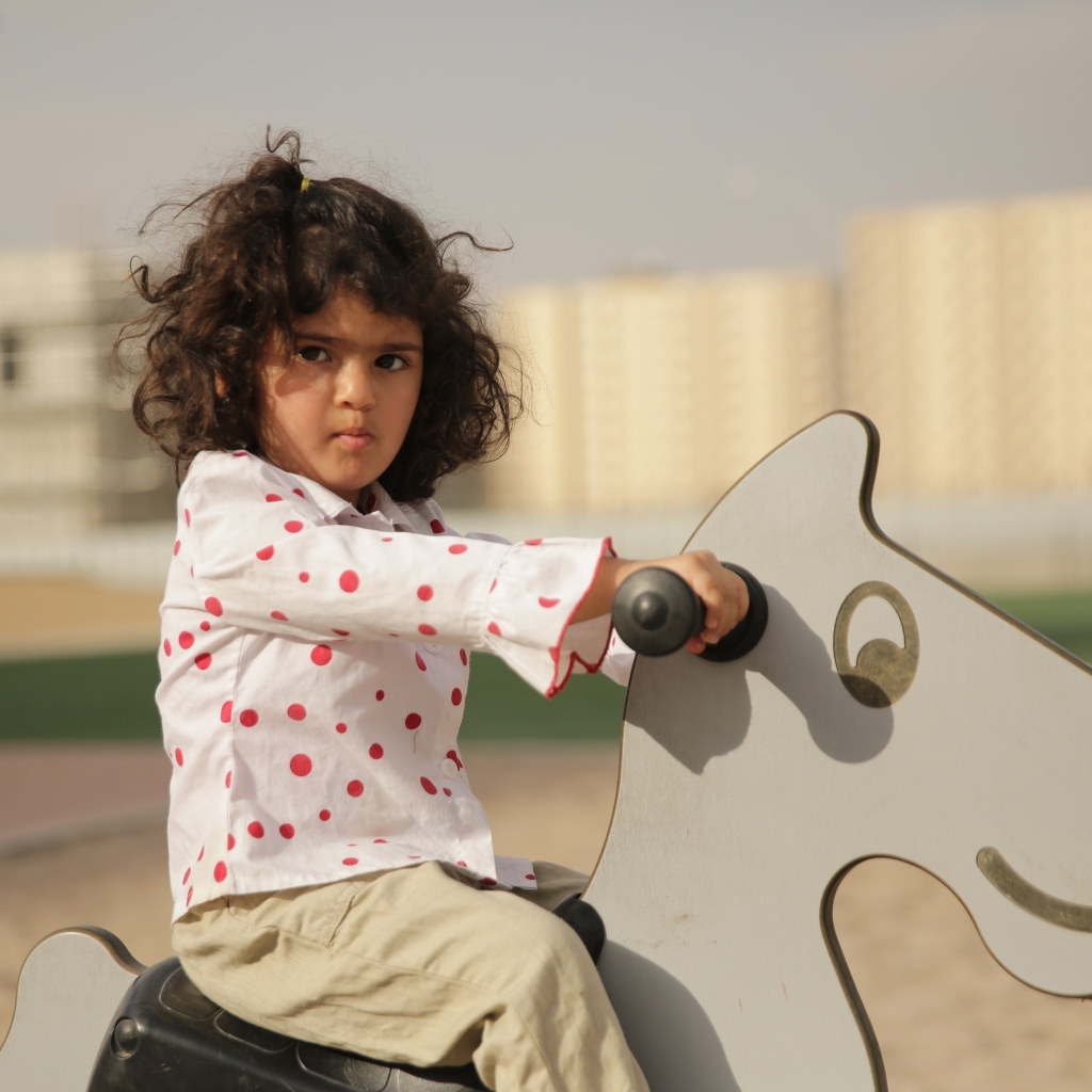 Маленькая девочка на деревянной лошади