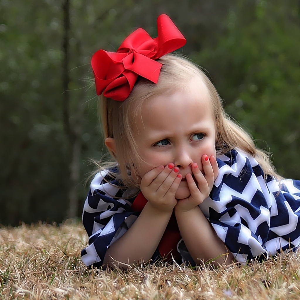Маленькая девочка с красным бантом на голове
