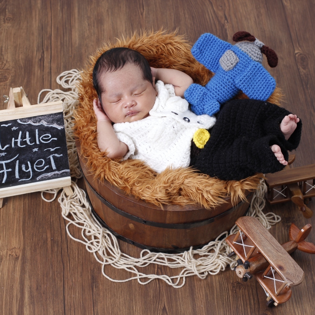 Маленький новорожденный малыш спит в бочке 