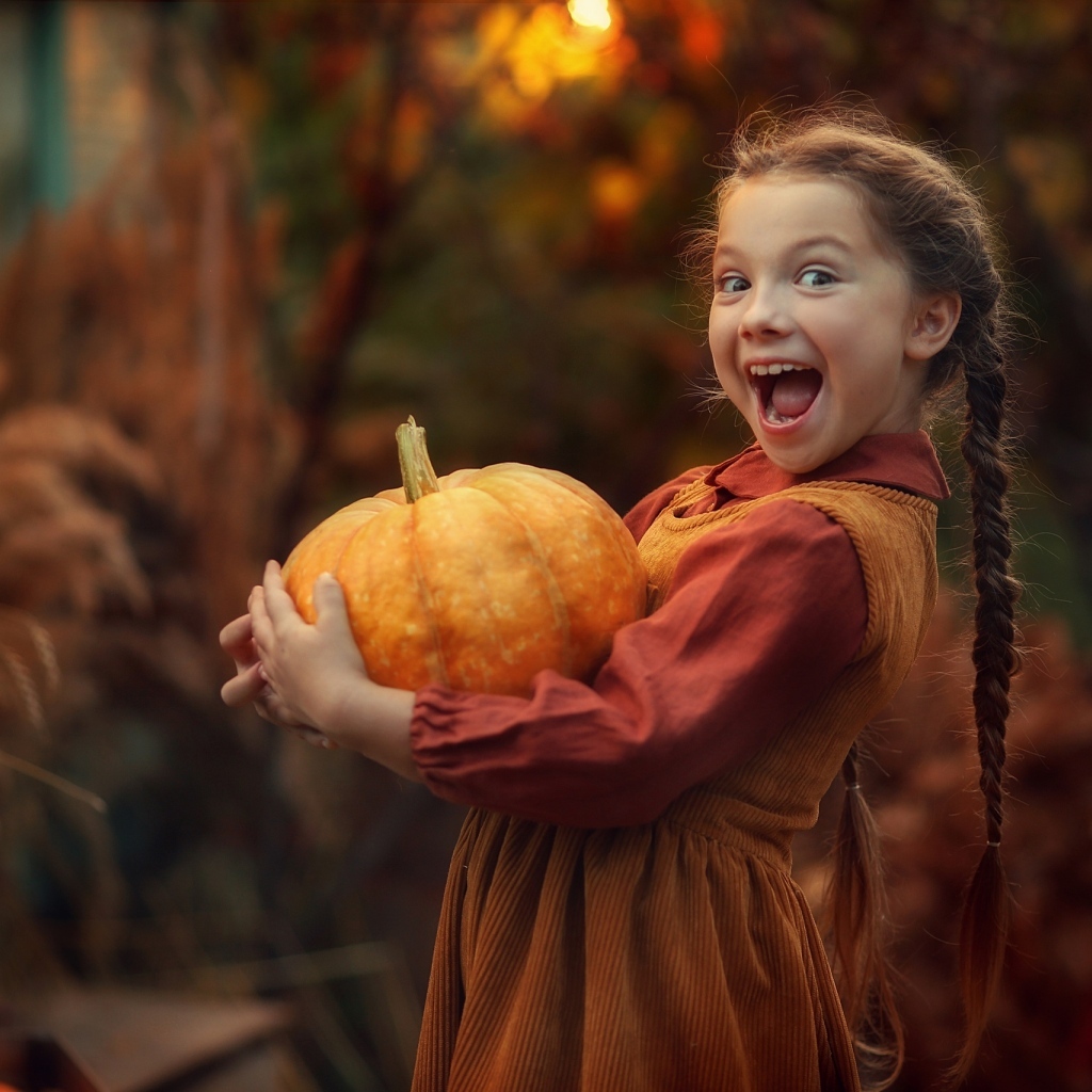 Маленькая рыжеволосая девочка с тыквой