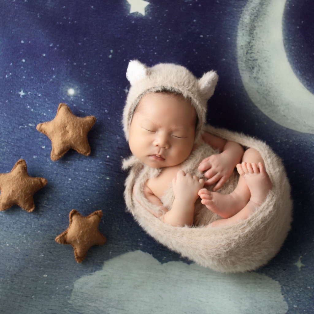 Маленький спящий грудной ребенок на синем покрывале