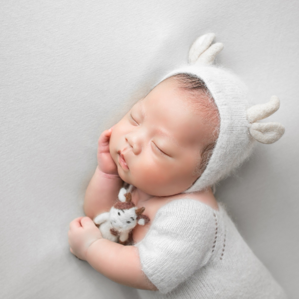 Маленький спящий малыш на сером фоне