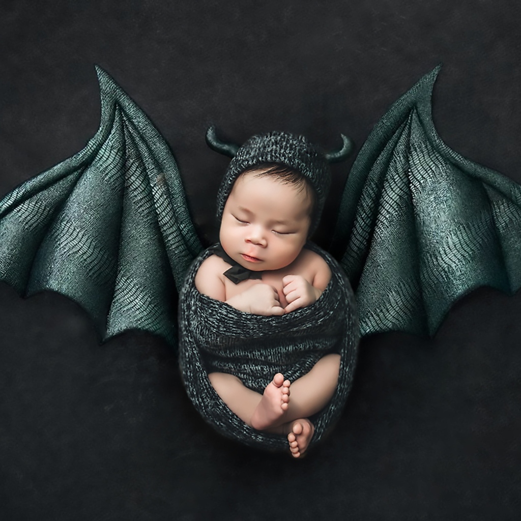 Маленький спящий ребенок с крыльями на Хэллоуин