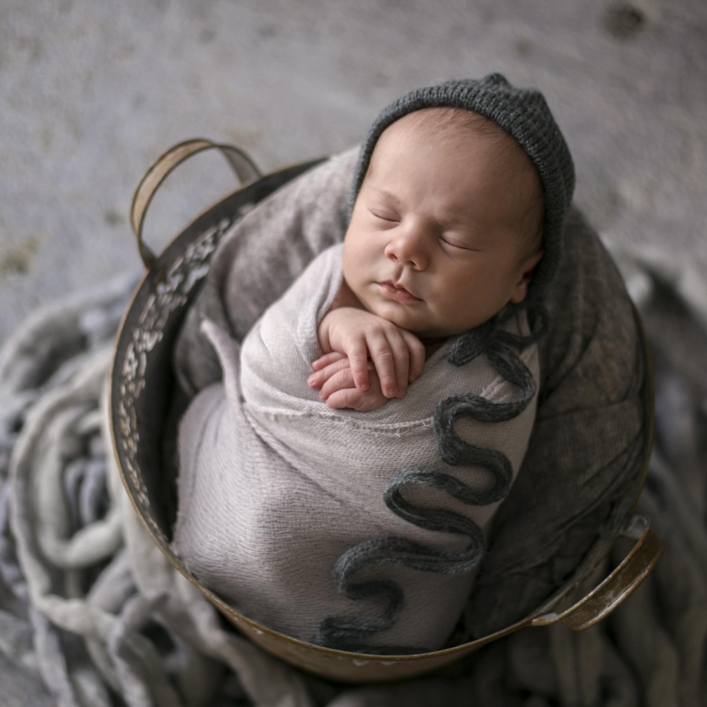 Маленький спящий новорожденный малыш в корзине