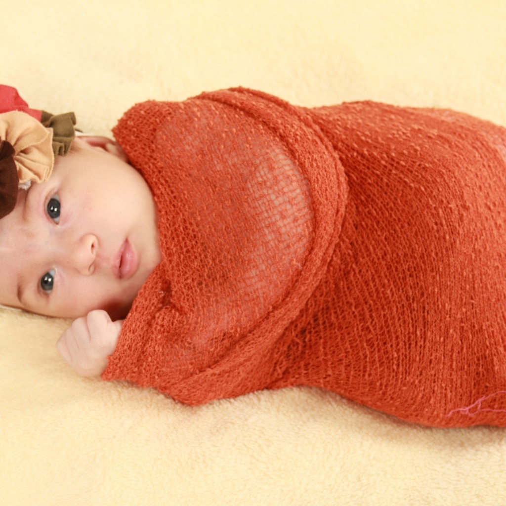 Новорожденная девочка в красном покрывале