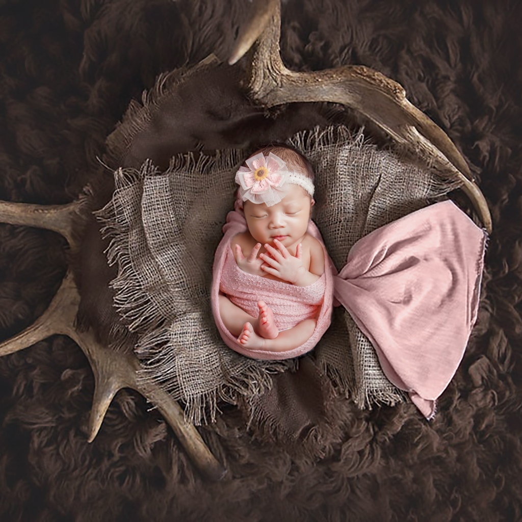 Новорожденная девочка на покрывале с рогами