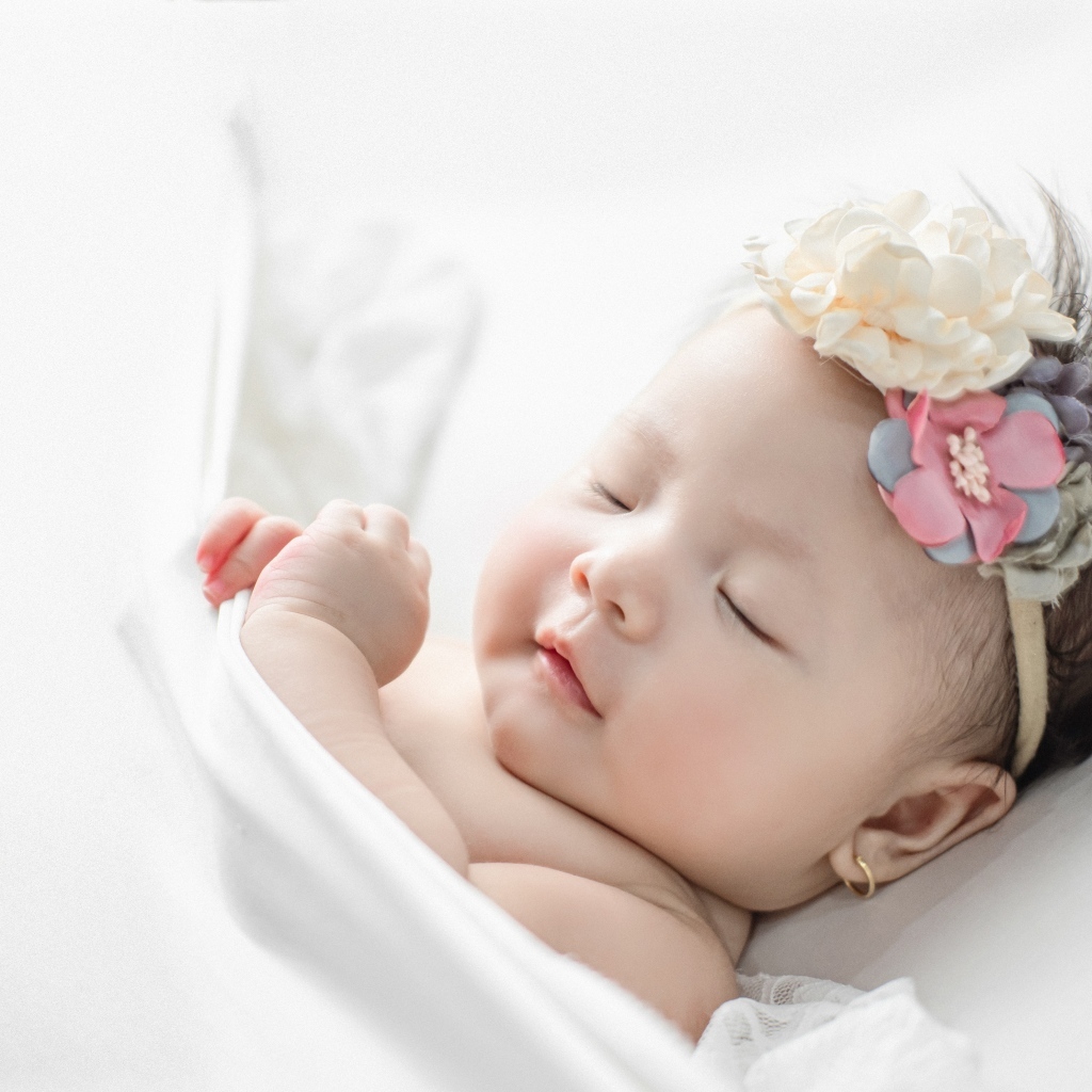 Новорожденная девочка с повязкой на голове
