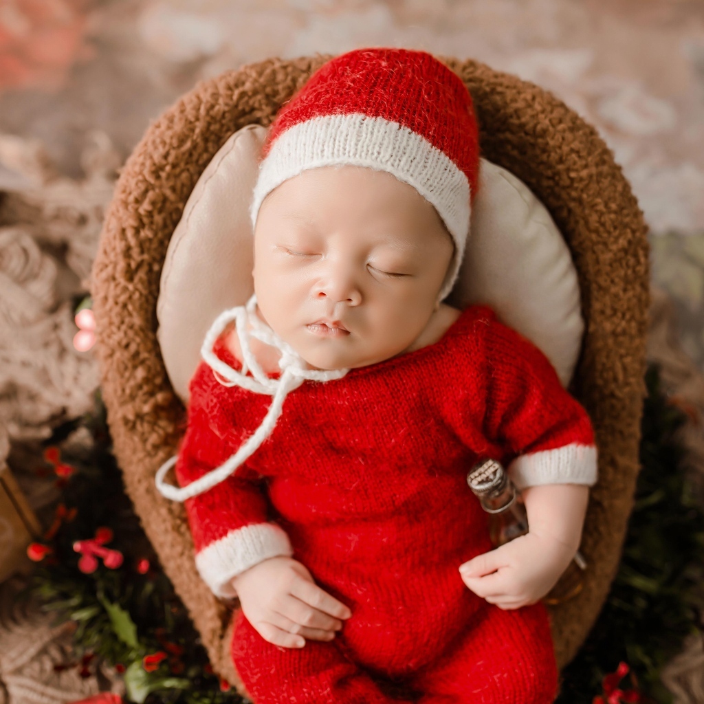 Новорожденный малыш в красном вязаном костюме