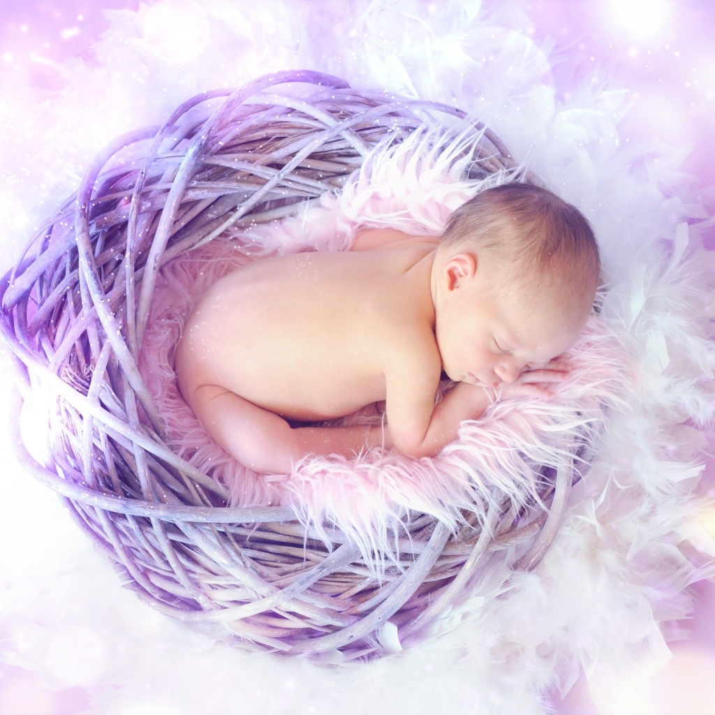 Новорожденный ребенок спит в сиреневом гнезде