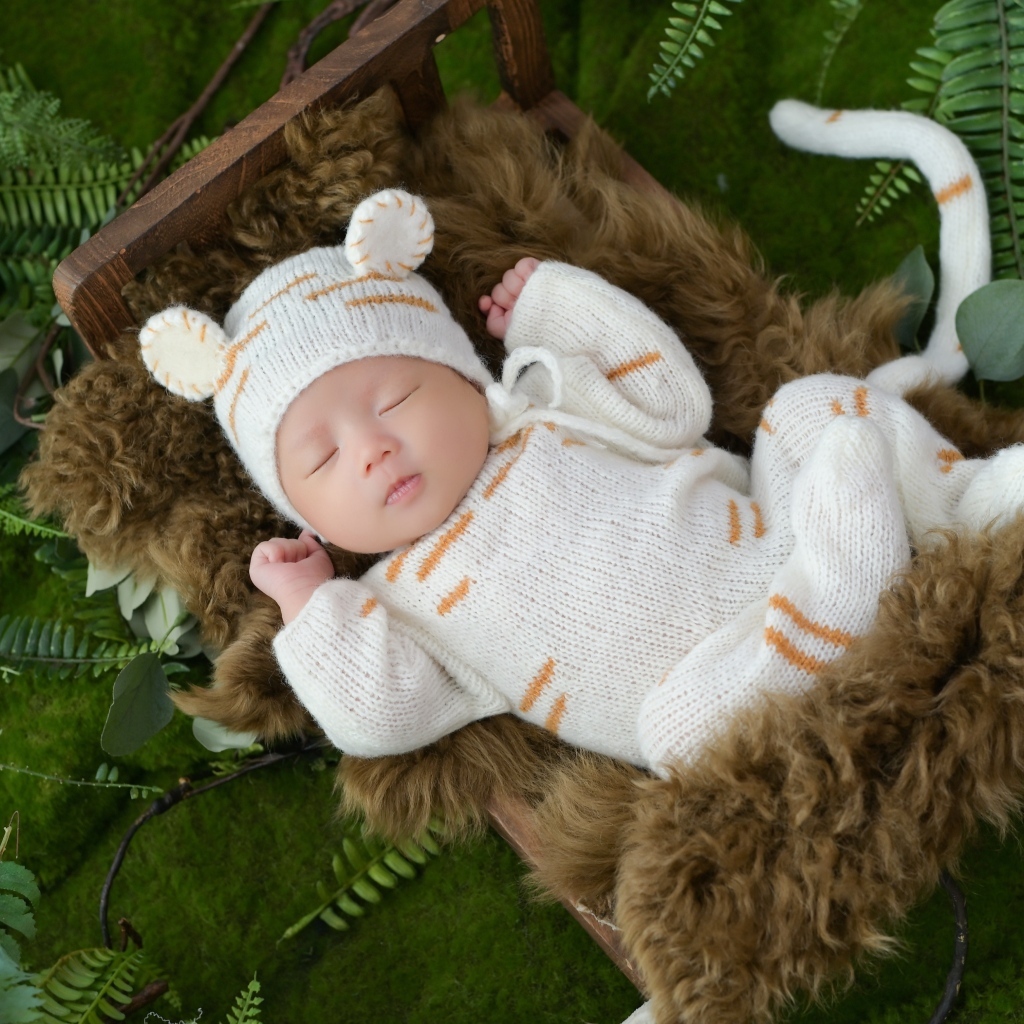 Спящий новорожденный ребенок в костюме тигренка