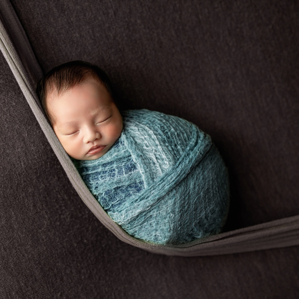 Маленький спящий ребенок завернут в покрывало