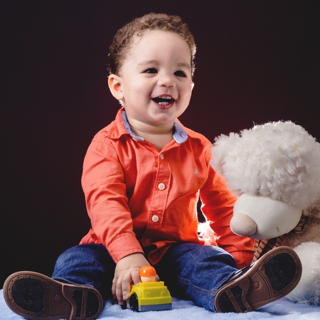 Улыбающийся мальчик с игрушечным медведем