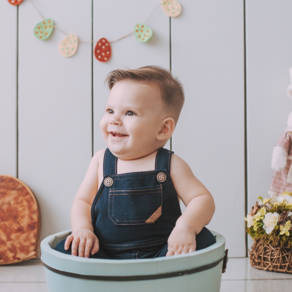 Улыбающийся ребенок сидит в ведре 