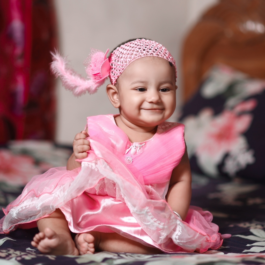 Улыбающаяся девочка в красивом розовом платье