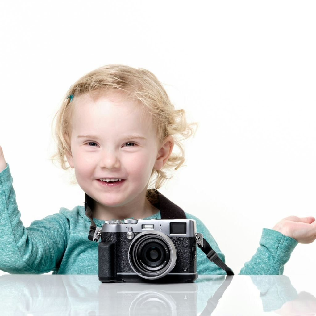 Улыбающаяся девочка с фотоаппаратом 