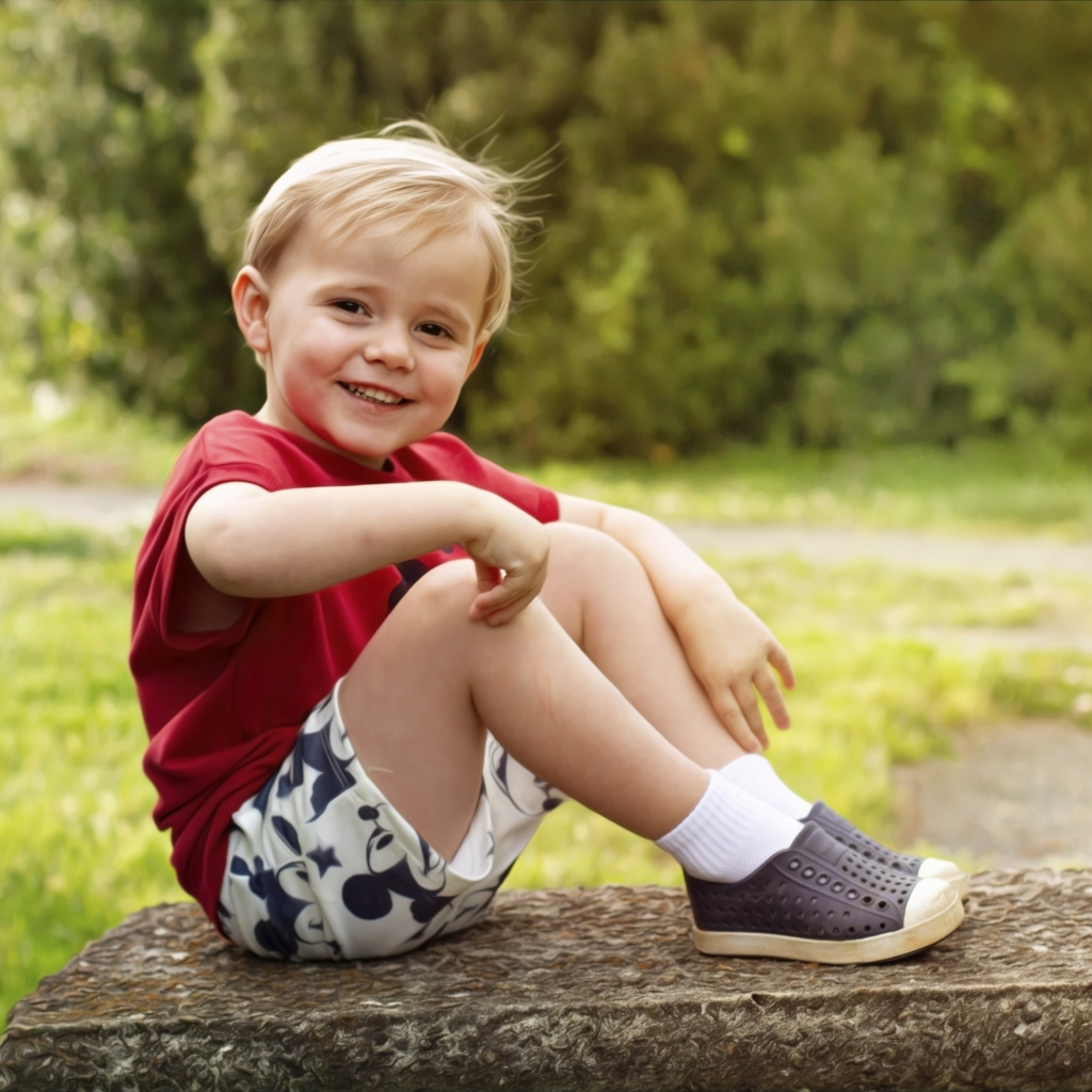 Улыбающийся маленький мальчик в красной футболке
