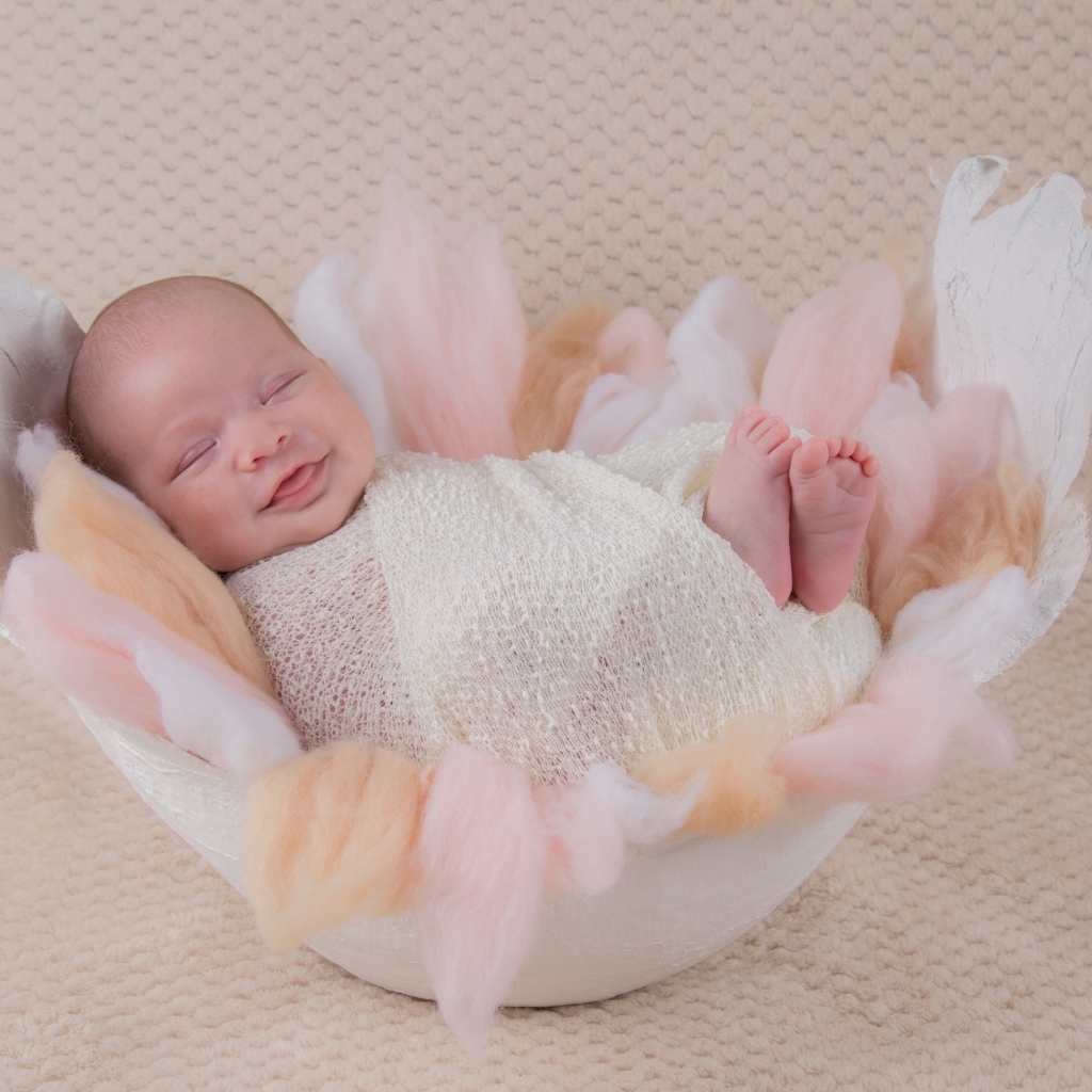 Улыбающийся спящий новорожденный малыш