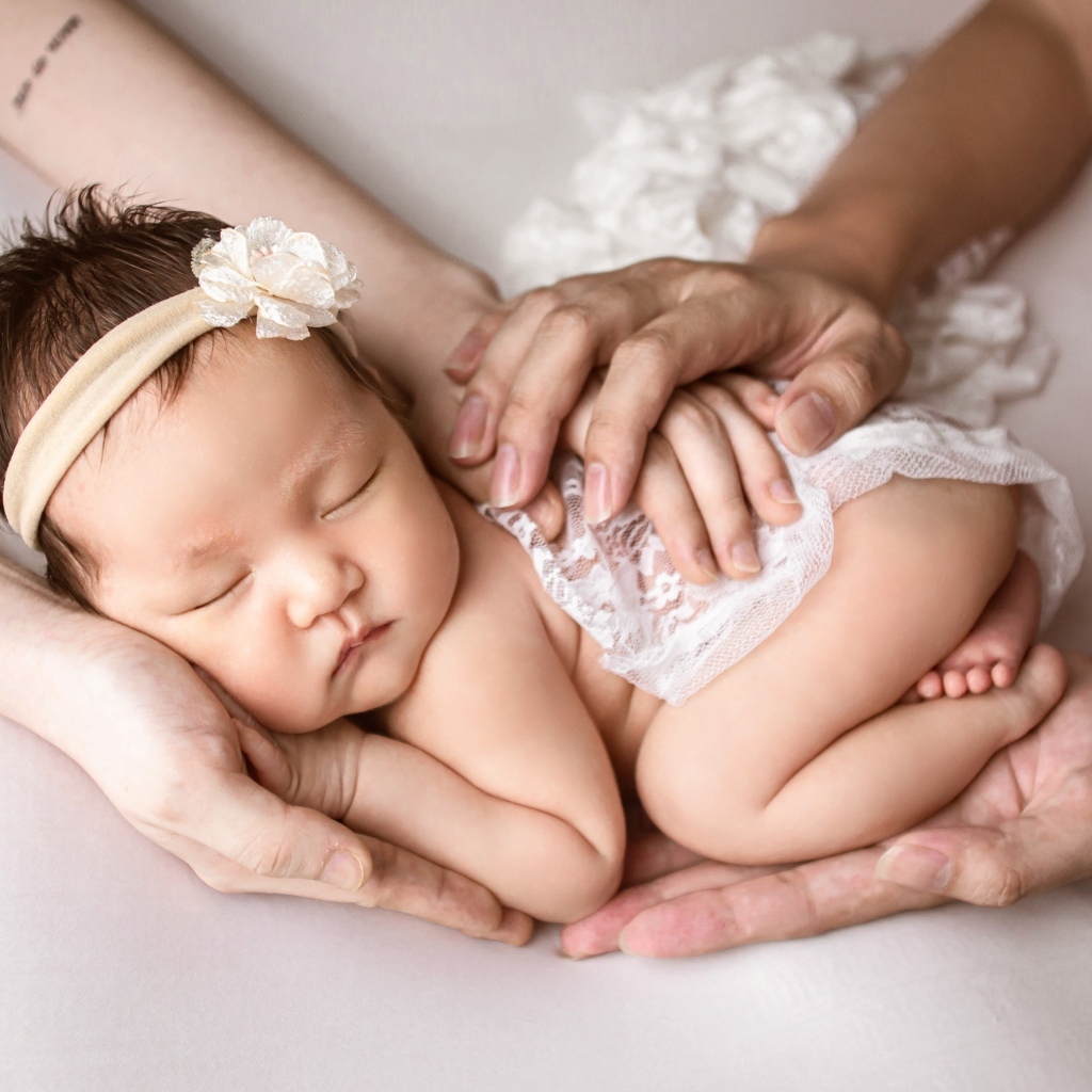 Руки родителей оберегают спящего малыша