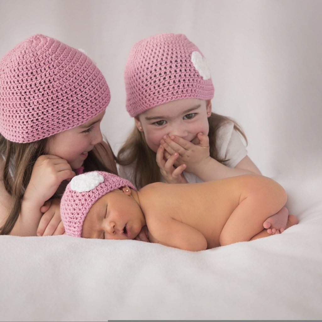 Три маленькие девочки в вязаных шапках