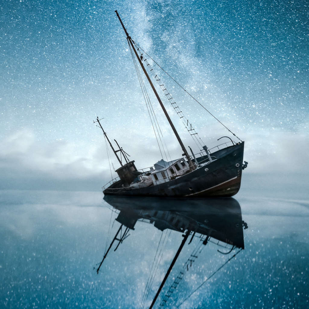 Затонувшая лодка в воде под красивым небом