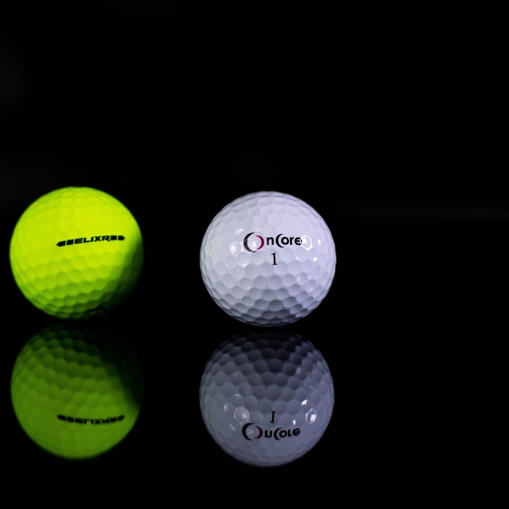 Два мяча для гольфа на черном фоне
