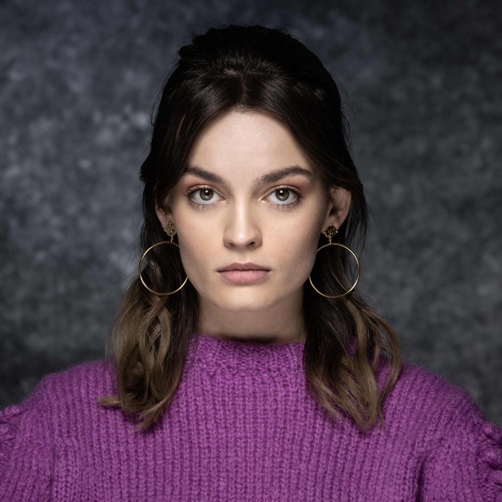 Актриса Эмма Маки на сером фоне