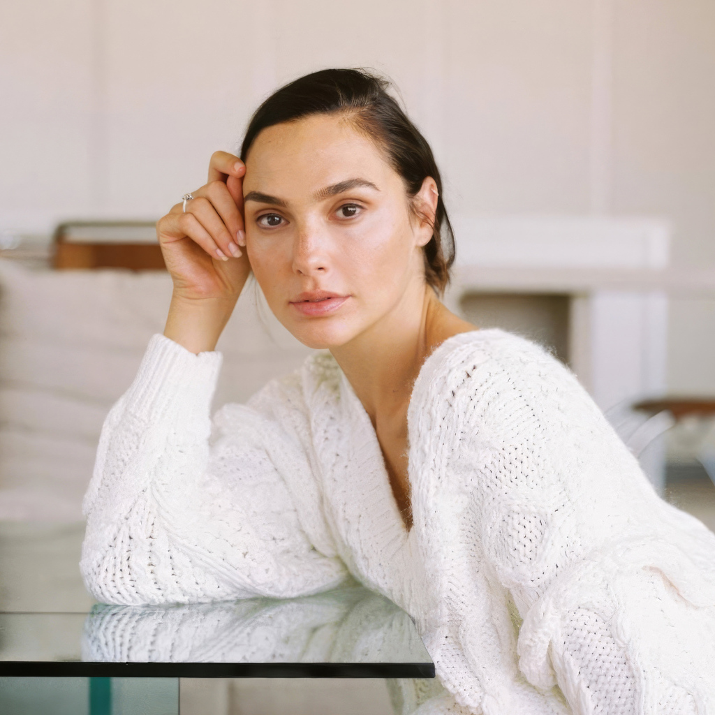 Актриса Галь Гадот в белом свитере за столом