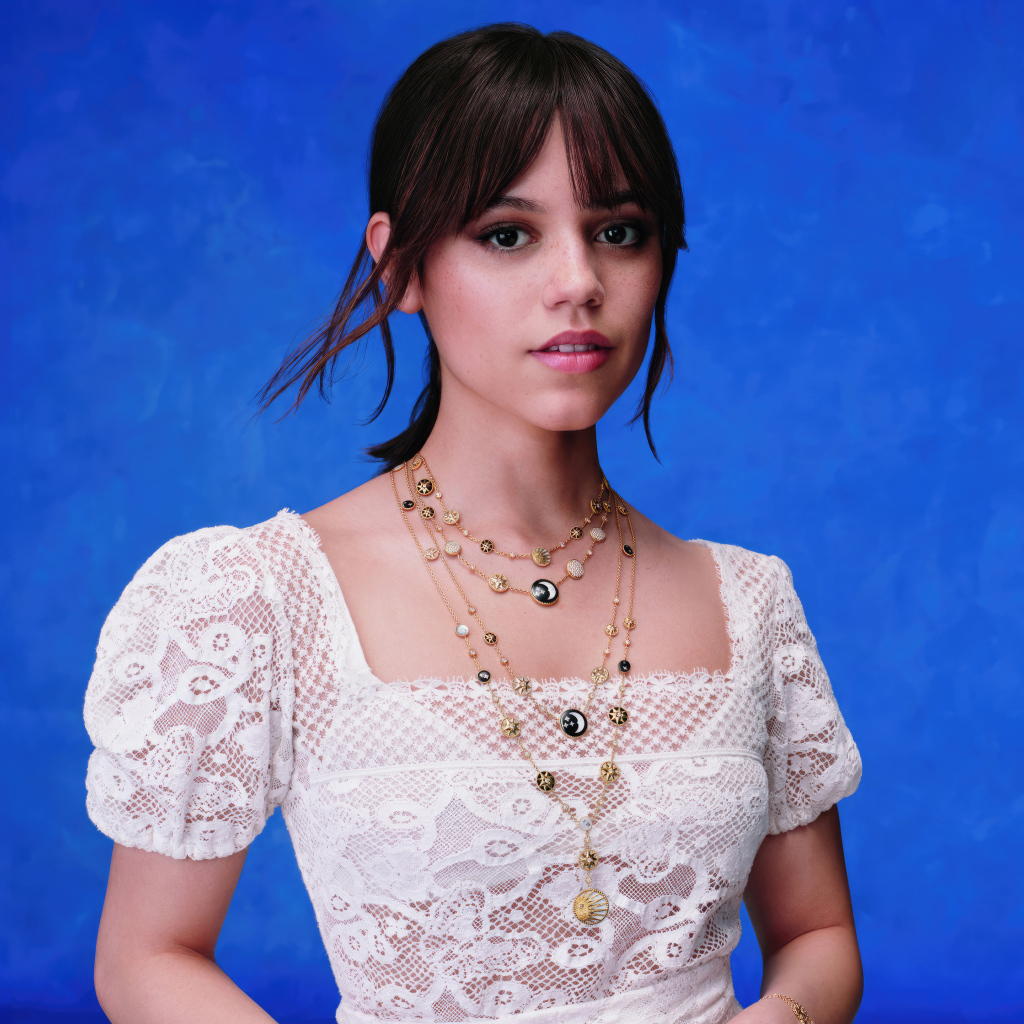 Актриса Дженна Ортега в белом платье на голубом фоне