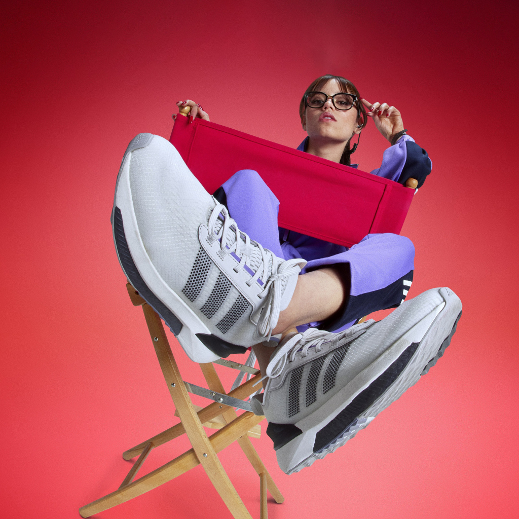 Актриса Дженна Ортега в кроссовках адидас сидит на стуле