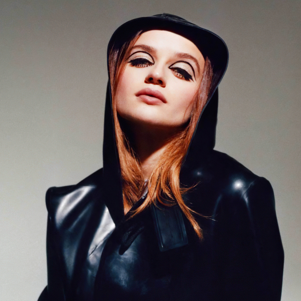 Актриса Джоуи Кинг в черной куртке на сером фоне