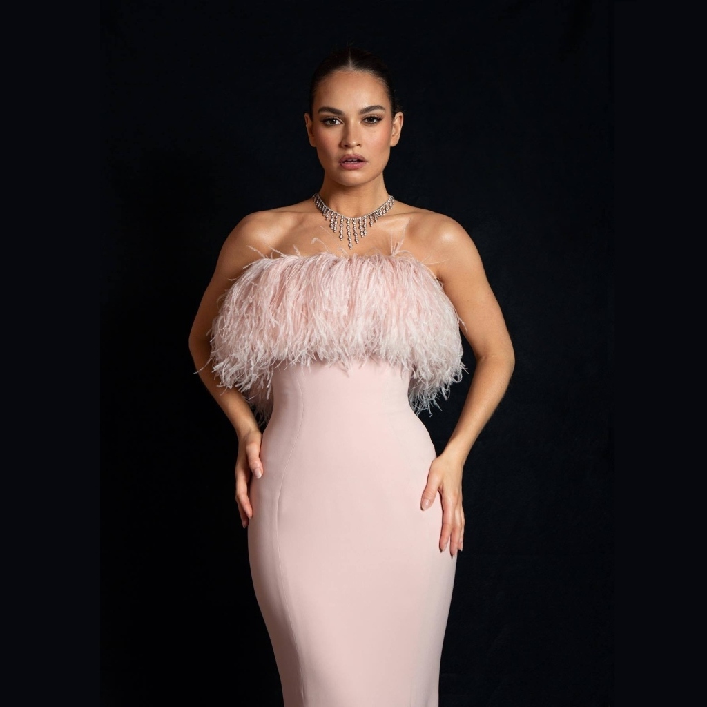 Актриса Лили Джеймс в розовом платье на черном фоне