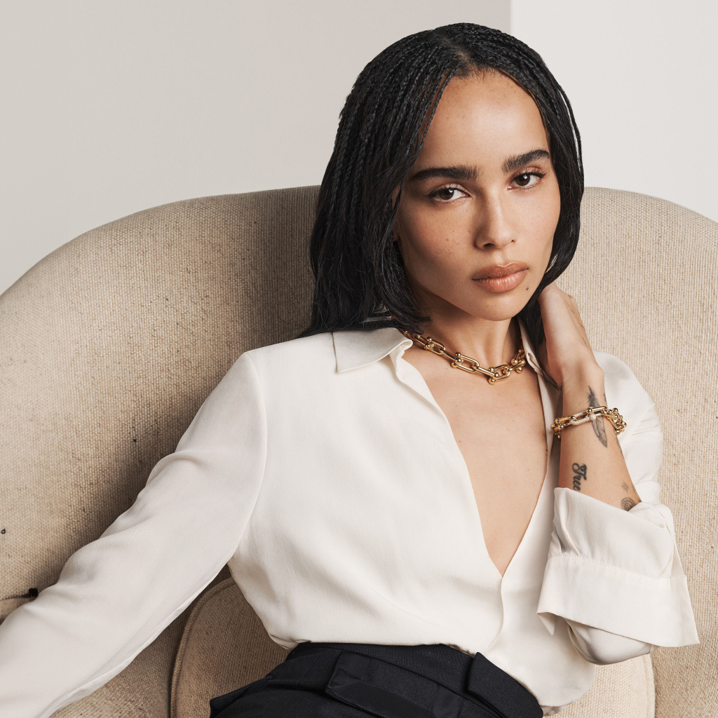 Актриса Зои Кравиц в белой рубашке сидит в кресле