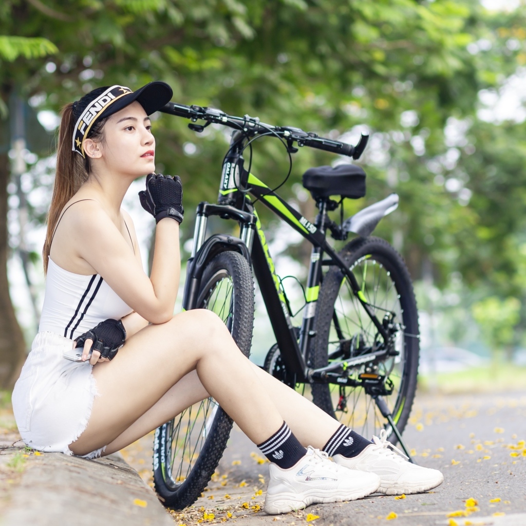 Спортивная девушка азиатка с велосипедом