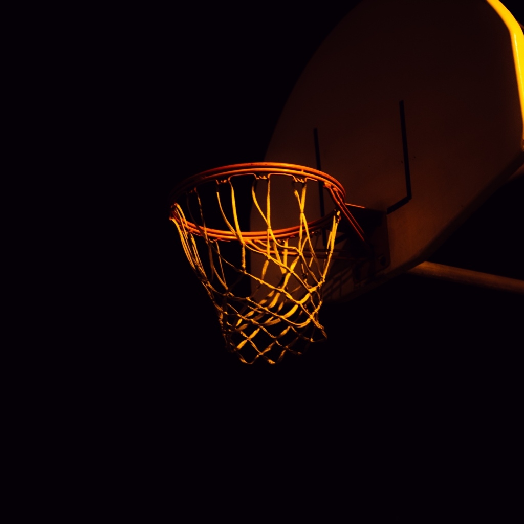 Баскетбольное кольцо в лучах света ночью