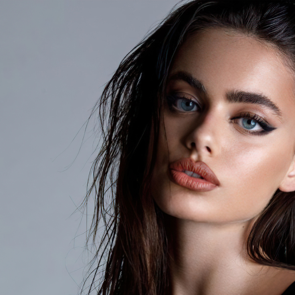 Красивая голубоглазая девушка Яэль Шелбиа на сером фоне