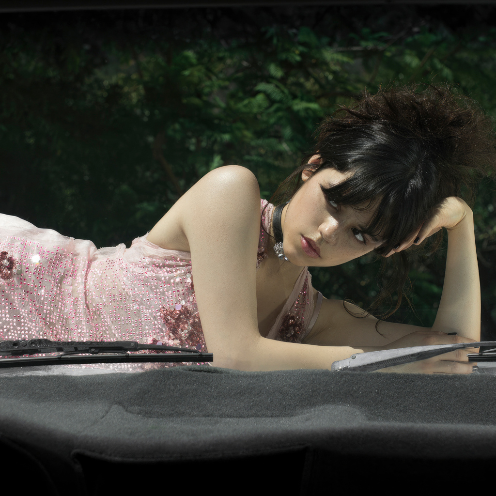 Красивая молодая актриса Дженна Ортега лежит на автомобиле