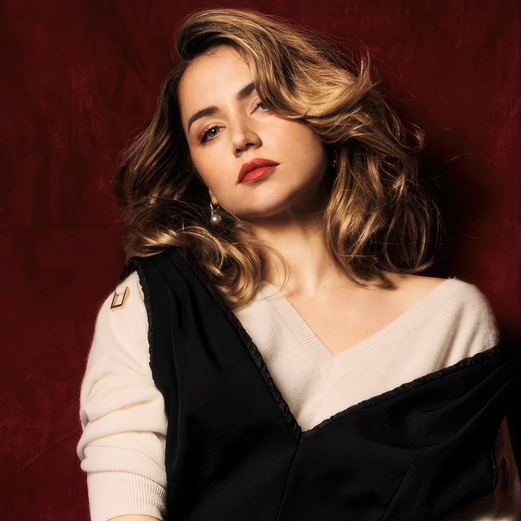 Милая актриса Ана де Армас стоит у красной стены