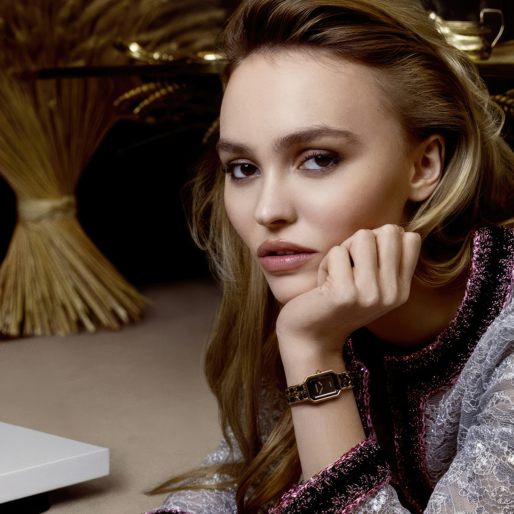 Милая девушка Лили-Роуз Депп сидит за столом