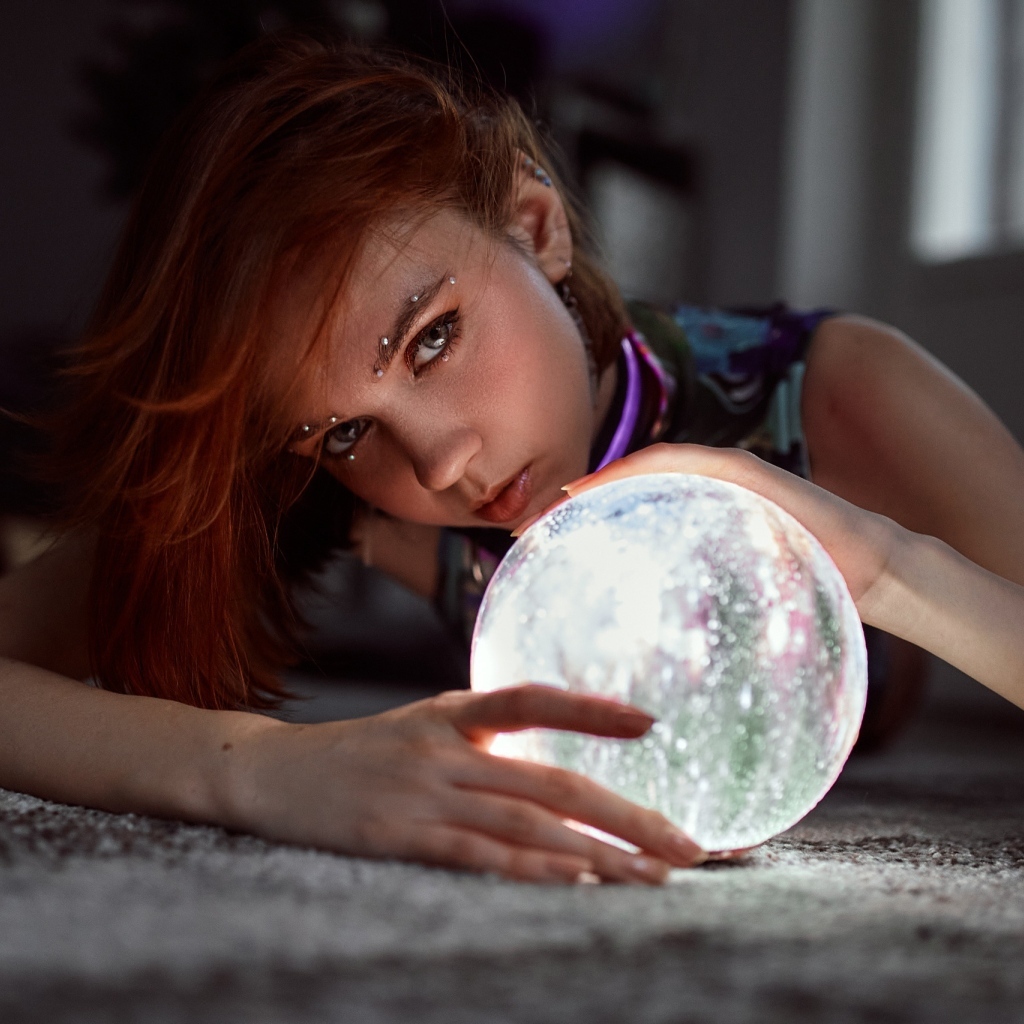 Девушка с пирсингом держит волшебный шар