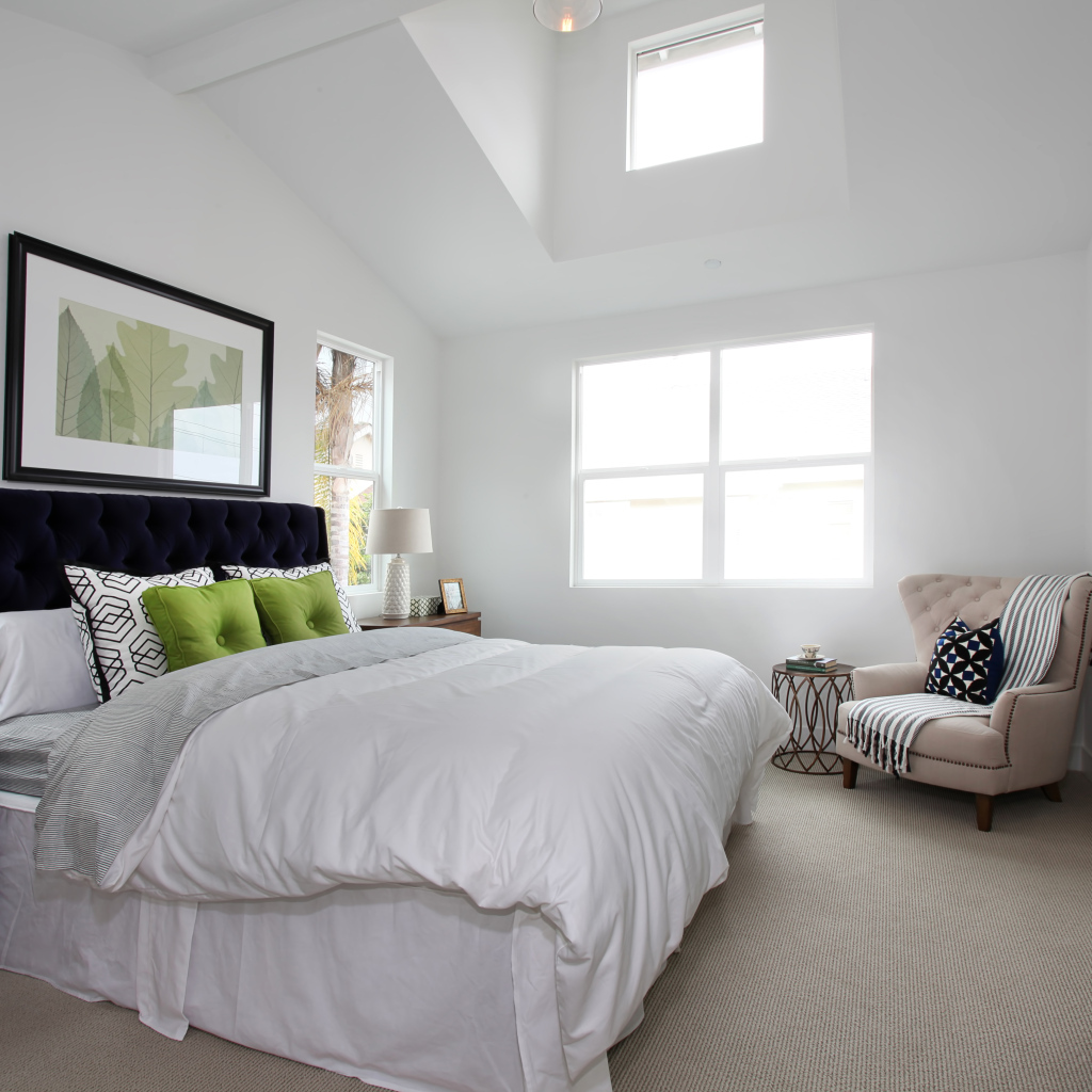 Высокая мягкая кровать в спальной комнате