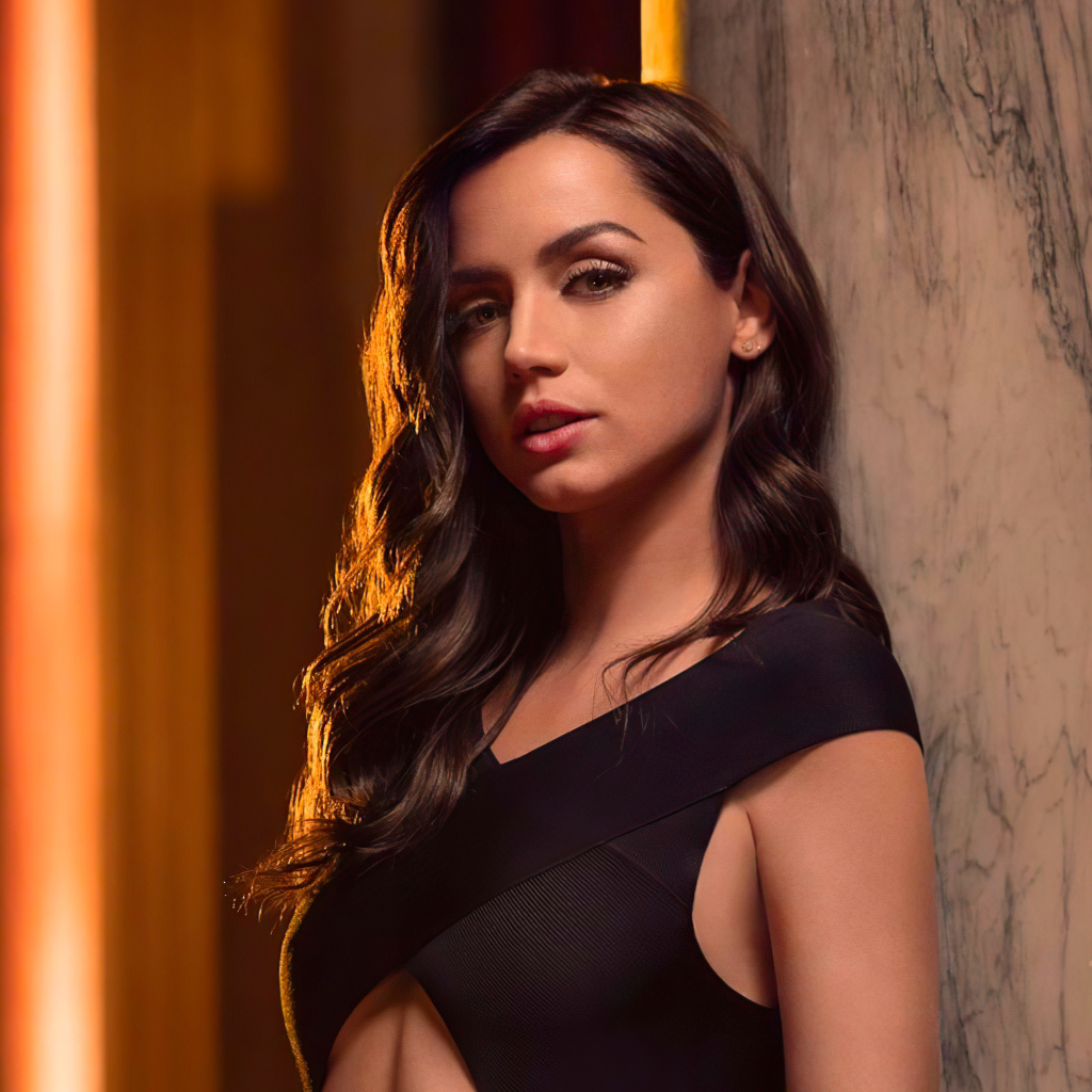 Длинноволосая актриса Ана де Армас стоит у стены