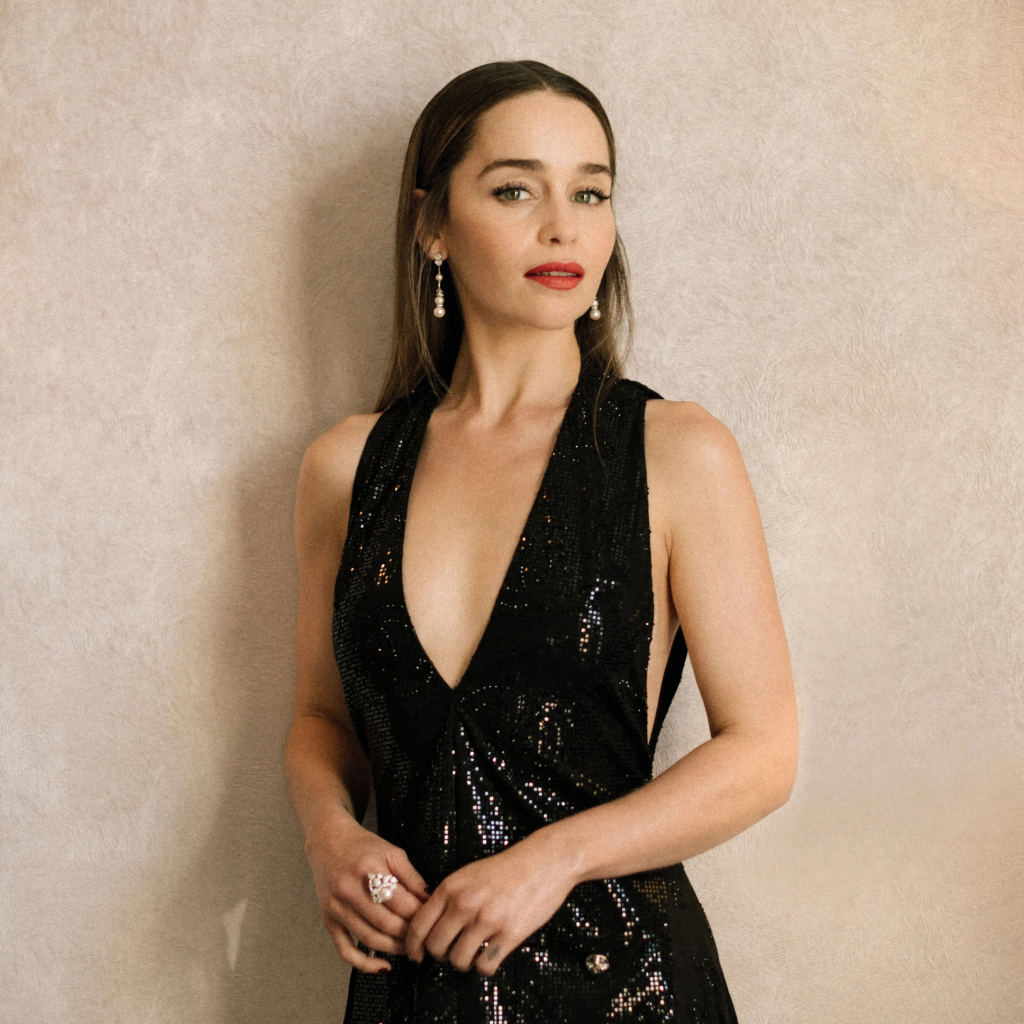 Популярная молодая актриса Эмилия Кларк в черном платье у стены