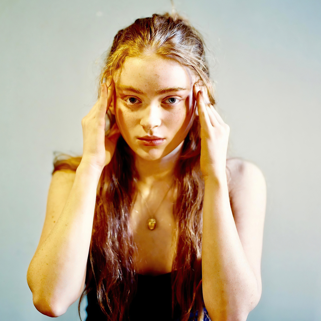 Рыжеволосая американская актриса Сэди Синк на сером фоне