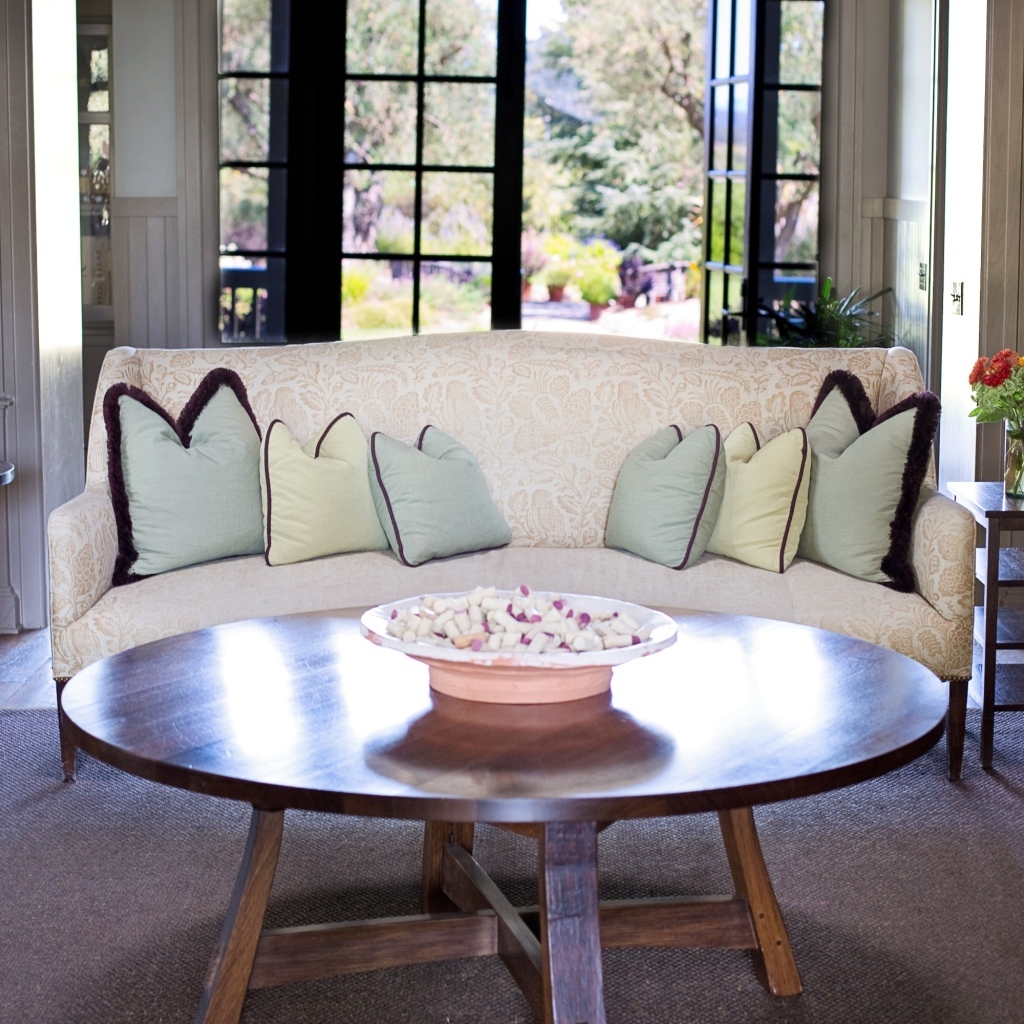 Круглый деревянный стол в гостиной с диваном